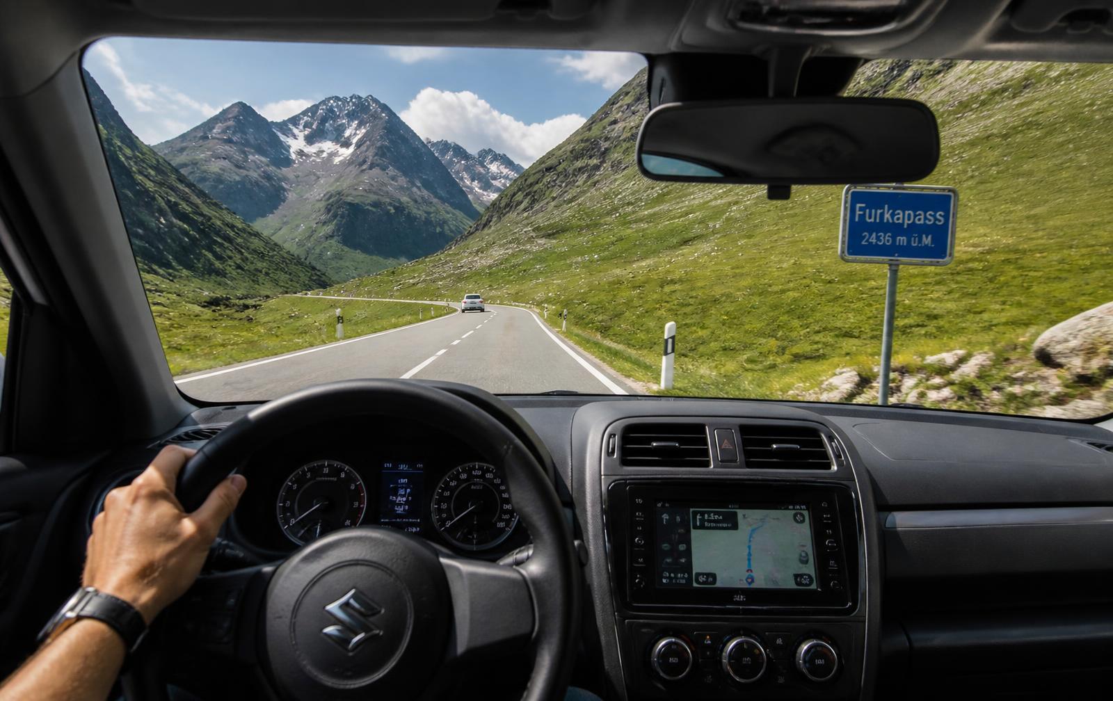 Blick aus dem Fahrzeuginnenraum auf eine Passstrasse in den Schweizer Alpen