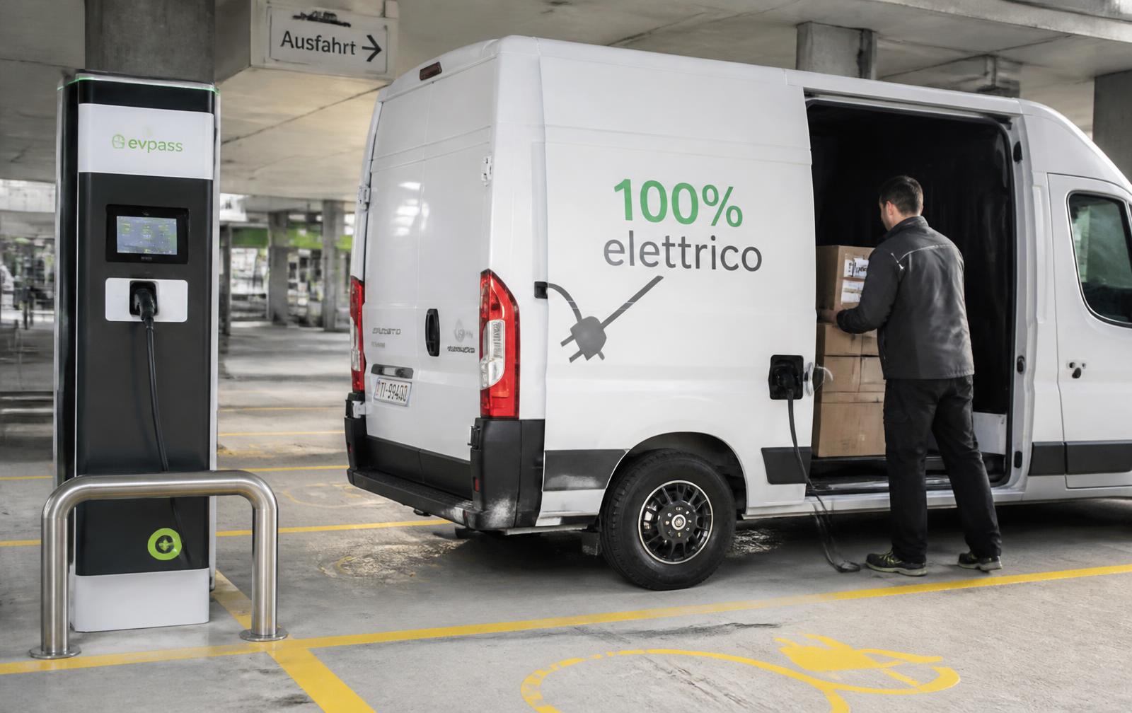 Elektrischer Transporter wird in einer Parkgarage geladen, eine Person lädt Kartons ein